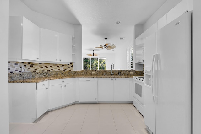 kitchen with white cabinetry, white appliances, sink, and dark stone countertops