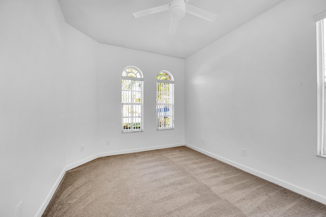 carpeted empty room with ceiling fan and vaulted ceiling