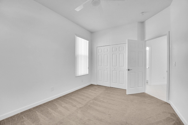 unfurnished bedroom with light colored carpet and a closet