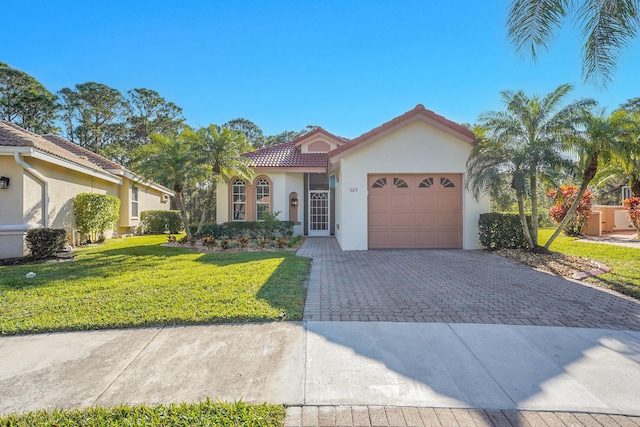 mediterranean / spanish-style house featuring a garage and a front lawn