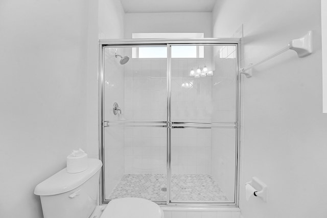 bathroom with an enclosed shower and toilet