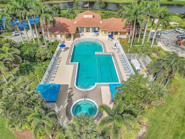 view of swimming pool with a patio area and a water view