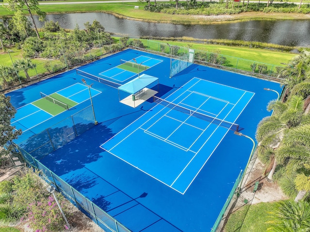 view of tennis court with a water view