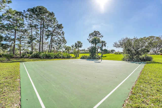 surrounding community featuring basketball hoop and a lawn