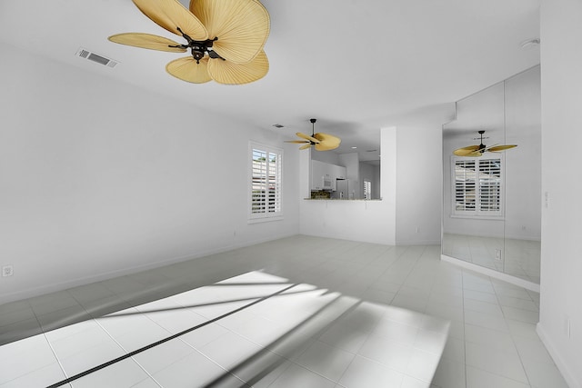 unfurnished living room featuring ceiling fan and light tile patterned floors