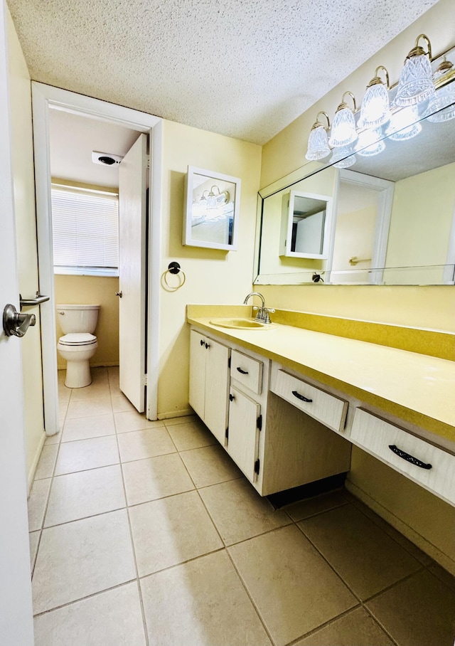 bathroom featuring tile patterned flooring, vanity, a textured ceiling, and toilet