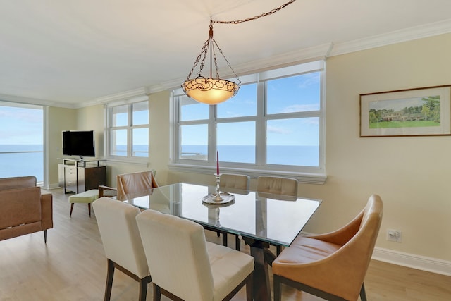 dining room featuring crown molding, plenty of natural light, and light wood-type flooring