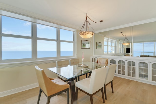 dining space featuring ornamental molding, plenty of natural light, and light hardwood / wood-style floors