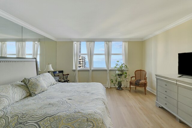 bedroom with ornamental molding and light hardwood / wood-style floors