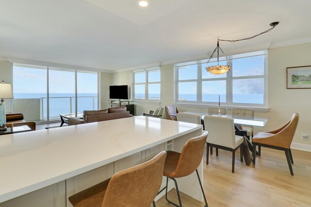 kitchen with appliances with stainless steel finishes, white cabinetry, kitchen peninsula, a water view, and light wood-type flooring