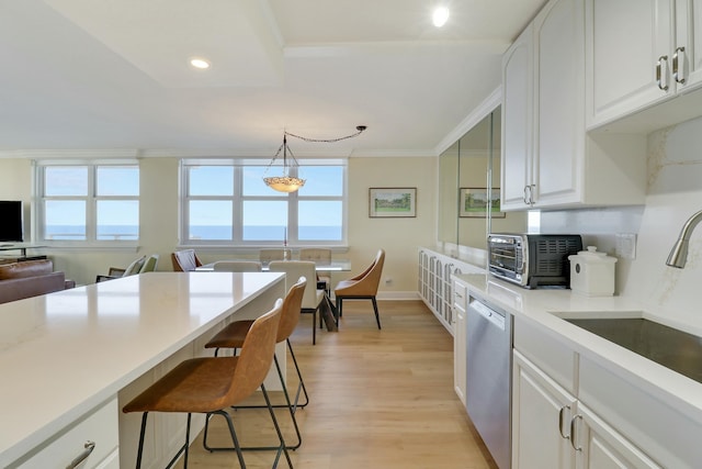 kitchen featuring white cabinetry, dishwasher, sink, hanging light fixtures, and ornamental molding