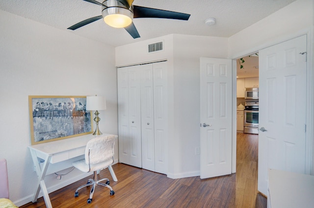 office area featuring ceiling fan, dark wood-type flooring, and a textured ceiling