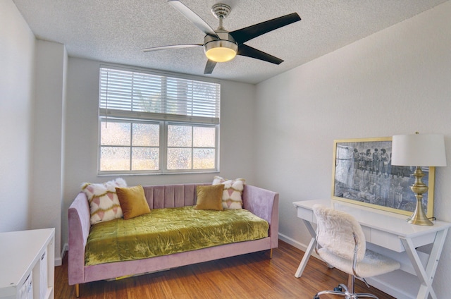 bedroom featuring hardwood / wood-style flooring, ceiling fan, and a textured ceiling