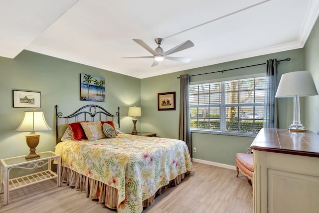 bedroom with ornamental molding, ceiling fan, and light wood-type flooring