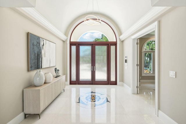 foyer with french doors, a chandelier, and vaulted ceiling