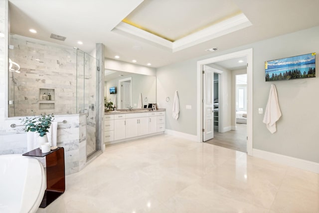 bathroom with a shower with door, vanity, and a tray ceiling