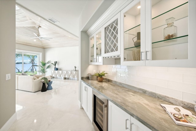 bar featuring tasteful backsplash, white cabinetry, beverage cooler, ceiling fan, and light stone countertops