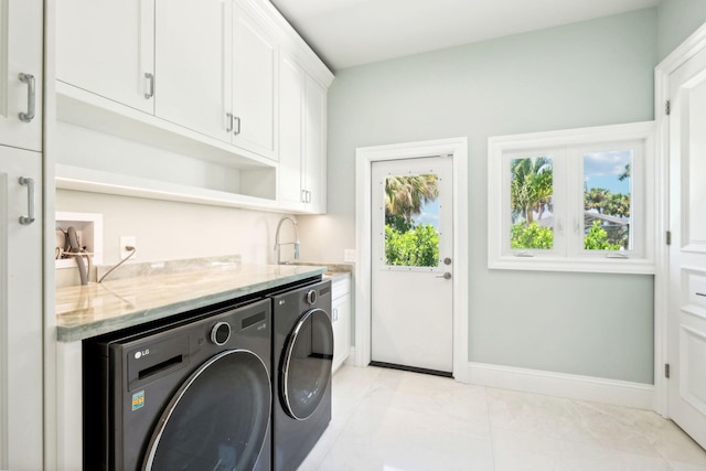 washroom with cabinets, separate washer and dryer, and light tile patterned floors