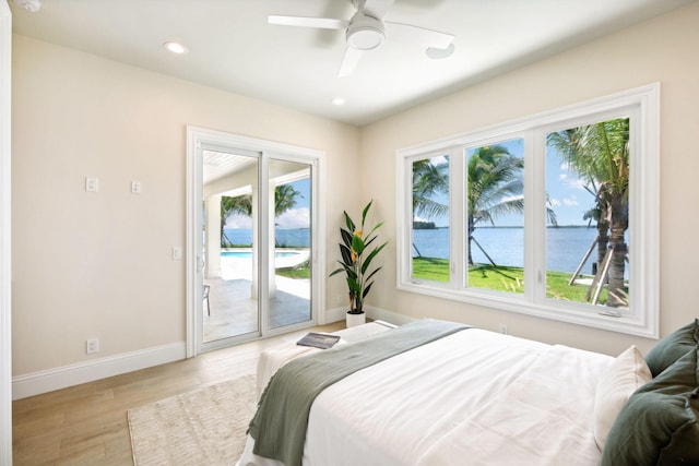 bedroom with ceiling fan, a water view, access to outside, and light hardwood / wood-style floors