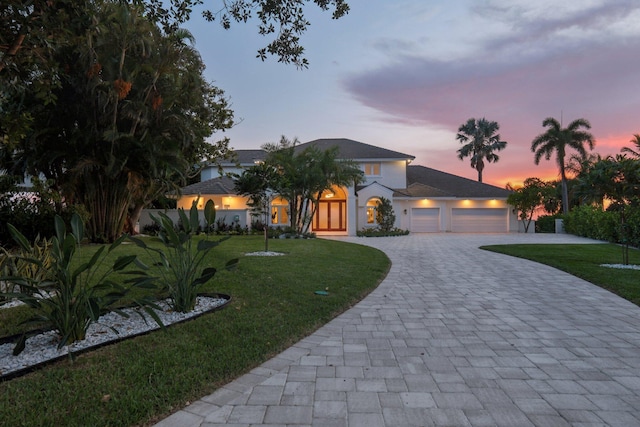 view of front of house with a garage and a lawn