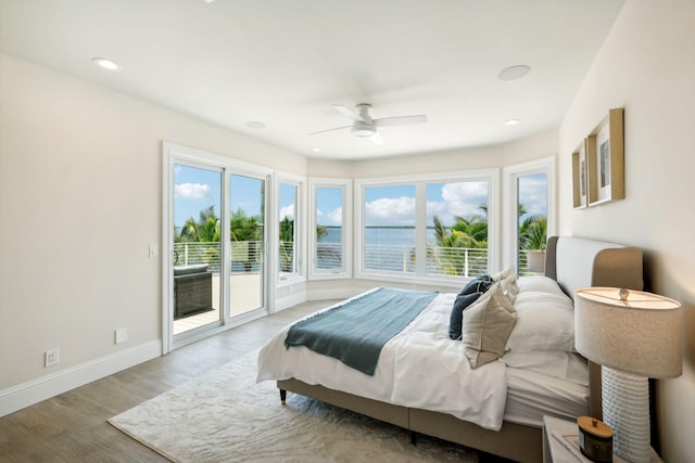 bedroom with ceiling fan, a water view, access to exterior, and light wood-type flooring