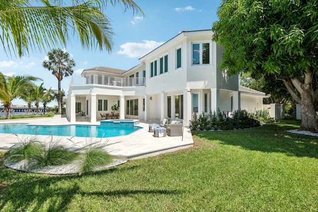 back of house with a balcony, a yard, a pool with hot tub, an outdoor living space, and a patio