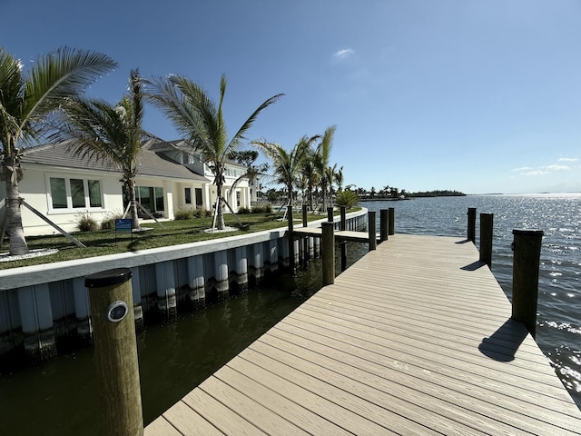 dock area featuring a water view and a lawn