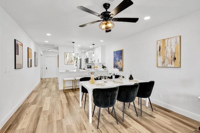 dining space featuring ceiling fan and light wood-type flooring