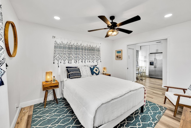 bedroom featuring stainless steel refrigerator with ice dispenser, ceiling fan, and wood-type flooring