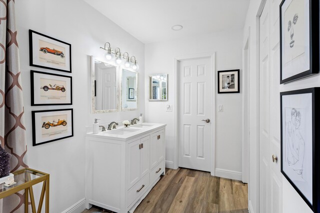 bathroom with wood-type flooring, vanity, and ceiling fan