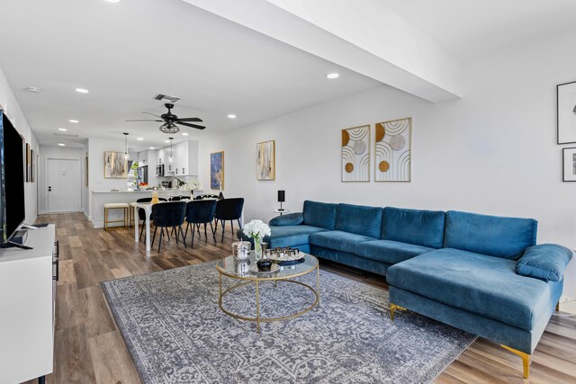 living room with light hardwood / wood-style flooring and ceiling fan