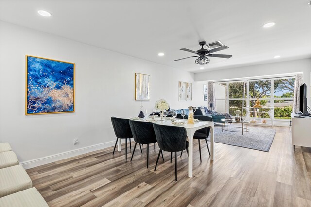 kitchen with appliances with stainless steel finishes, white cabinets, and light hardwood / wood-style flooring