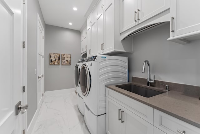 laundry room with cabinets, separate washer and dryer, and sink