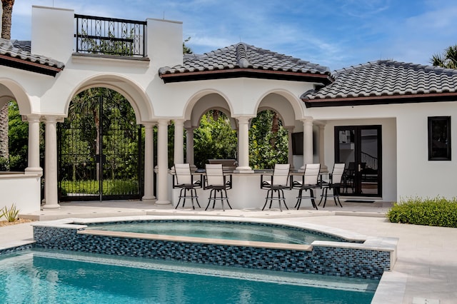 view of pool with an in ground hot tub, an outdoor bar, and a patio area