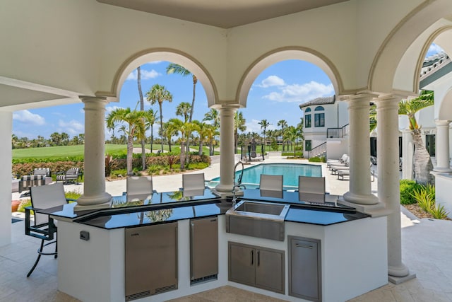 view of patio with an outdoor kitchen and exterior bar