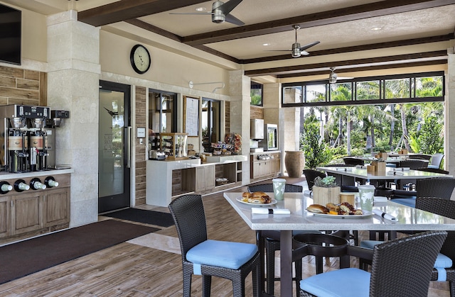 dining area featuring beam ceiling, ceiling fan, and light wood-type flooring