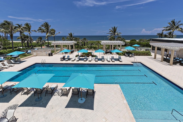 view of pool featuring a patio, a water view, and a pergola