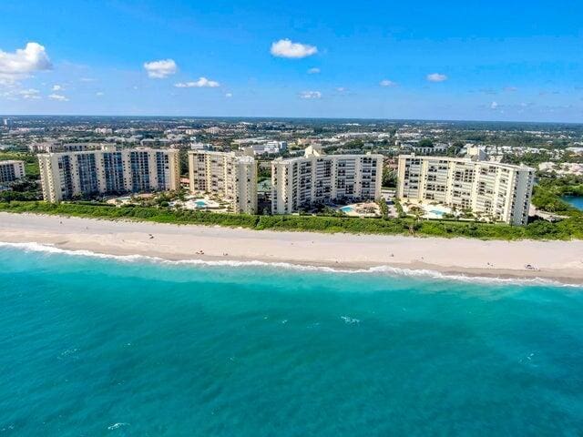 drone / aerial view featuring a water view and a beach view