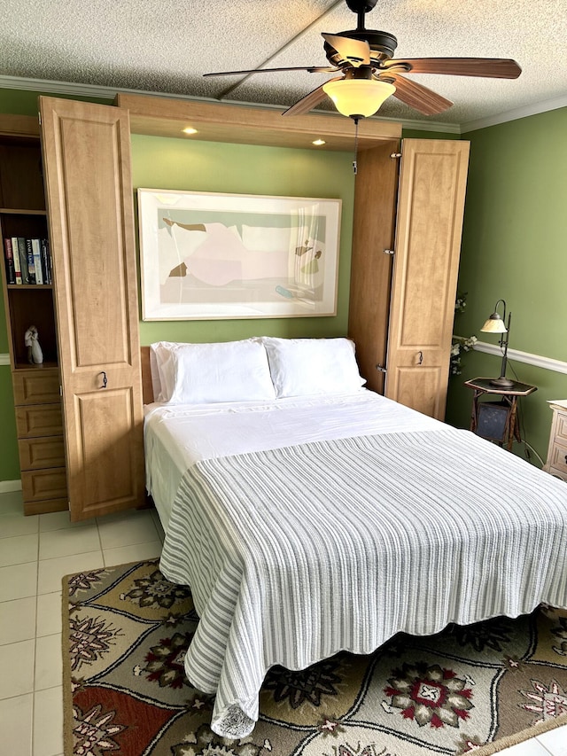 tiled bedroom featuring ornamental molding, ceiling fan, and a textured ceiling