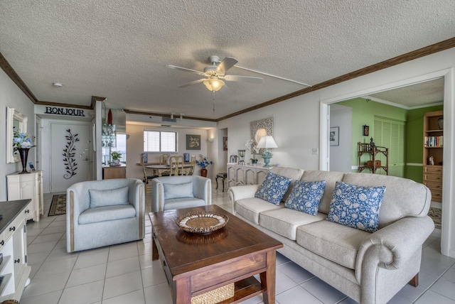 living room featuring crown molding, ceiling fan, a textured ceiling, and light tile patterned floors