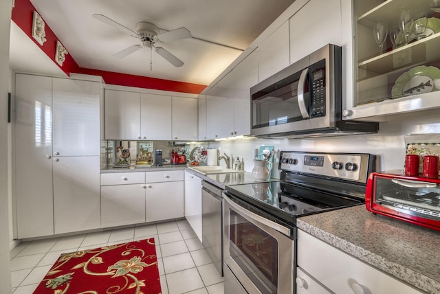 kitchen featuring white cabinetry, appliances with stainless steel finishes, sink, and light tile patterned floors