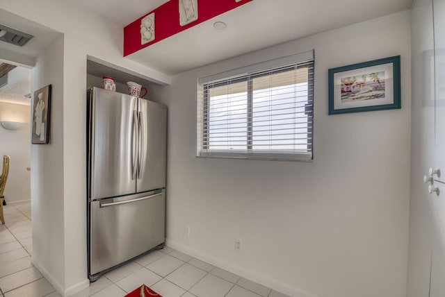 kitchen featuring light tile patterned flooring and stainless steel fridge