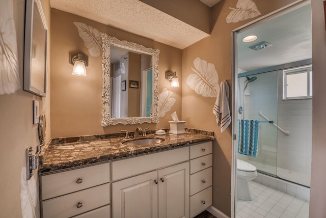 bathroom with tile patterned flooring, toilet, vanity, and walk in shower