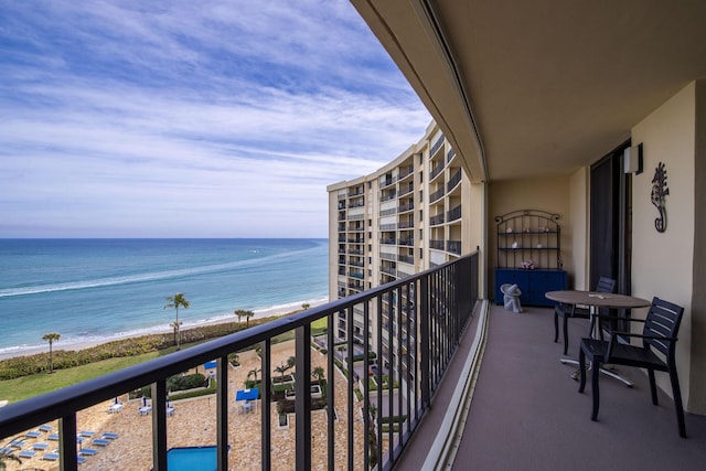 balcony with a water view and a view of the beach