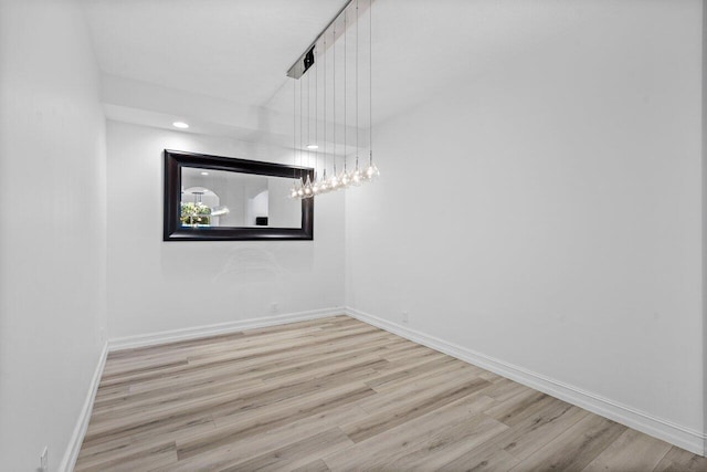 unfurnished room with baseboards and wood finished floors