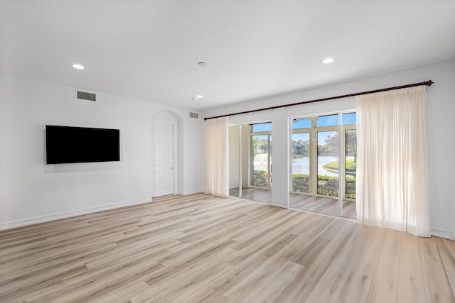 unfurnished living room featuring light wood-type flooring, visible vents, and recessed lighting