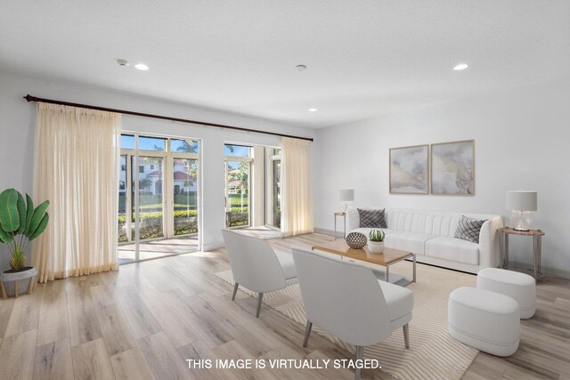 empty room with light colored carpet, a textured ceiling, and baseboards