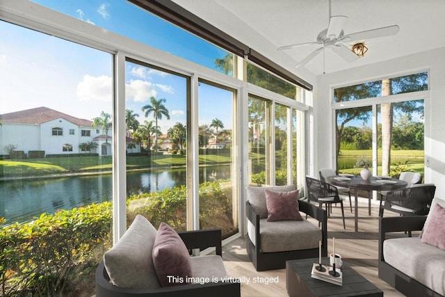 sunroom / solarium featuring a water view and ceiling fan