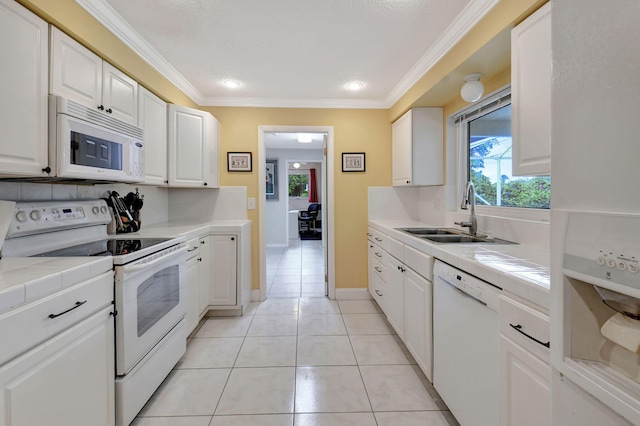 kitchen with sink, white cabinetry, ornamental molding, tile counters, and white appliances