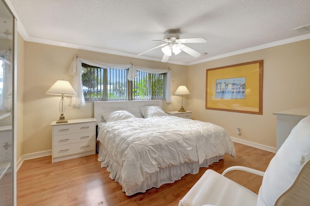 bedroom featuring crown molding, a textured ceiling, ceiling fan, and light hardwood / wood-style flooring